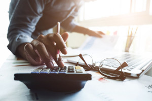 Close up of businessman or accountant hand holding pen working o